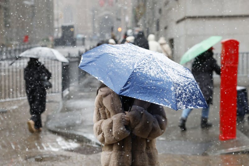 Pedestrians hold umbrellas as snow falls accompanied by cold temperatures on Wall Street in New York City on Friday, January 19, 2024. A third winter storm in the past few days descends on the tri-state area dumping up to 5 inches of snow in some spots which will be followed by freezing cold temperatures over the weekend. A break in the severe conditions is expected in the beginning of the week. Photo by John Angelillo/UPI