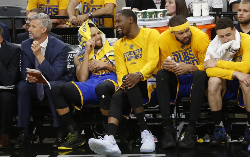 The Warriors’ Stephen Curry and Kevin Durant share a laugh in the closing minutes of Game 3 Saturday night. (AP)