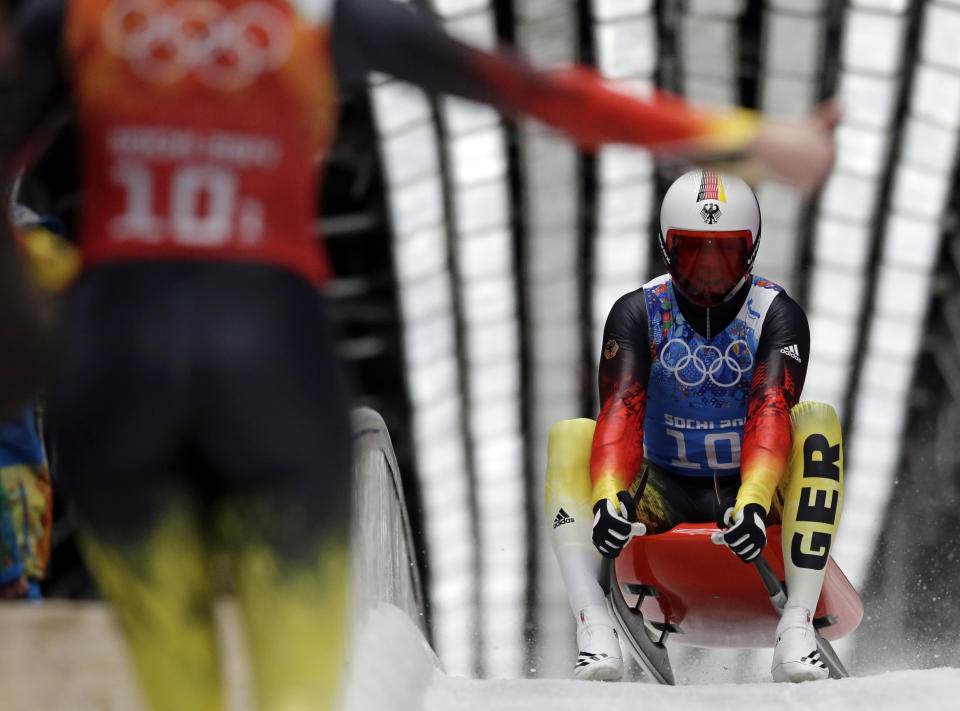 Germany's Felix Loch is greeted in the finisg area by teammate Natalie Geisenberger during the luge team relay competition at the 2014 Winter Olympics, Thursday, Feb. 13, 2014, in Krasnaya Polyana, Russia. The German team won the gold medal. (AP Photo/Michael Sohn)