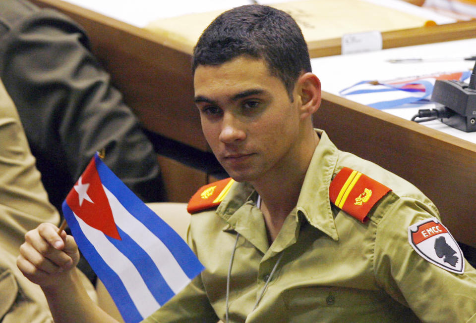 ARCHIVO - Elián González sostiene una bandera cubana durante el congreso de la Unión de Jóvenes Comunistas en La Habana, Cuba, el 4 de abril de 2010. (AP Foto/Ismael Francisco, Prensa Latina, File)