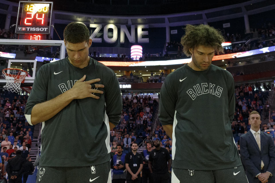 ORLANDO, FL - NOVEMBER 1: Brothers Brook Lopez #11 and Robin Lopez #42 of the Milwaukee Bucks during the National Anthem before the game against the Orlando Magic at the Amway Center on November 1, 2019 in Orlando, Florida. The Bucks defeated the Magic 123 to 91. NOTE TO USER: User expressly acknowledges and agrees that, by downloading and or using this photograph, User is consenting to the terms and conditions of the Getty Images License Agreement. (Photo by Don Juan Moore/Getty Images)