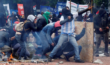 A protester uses a slingshot to hurl stones at the police during clashes outside the Congress, where the budget bill is being debated, in Buenos Aires, Argentina October 24, 2018. REUTERS/Martin Acosta