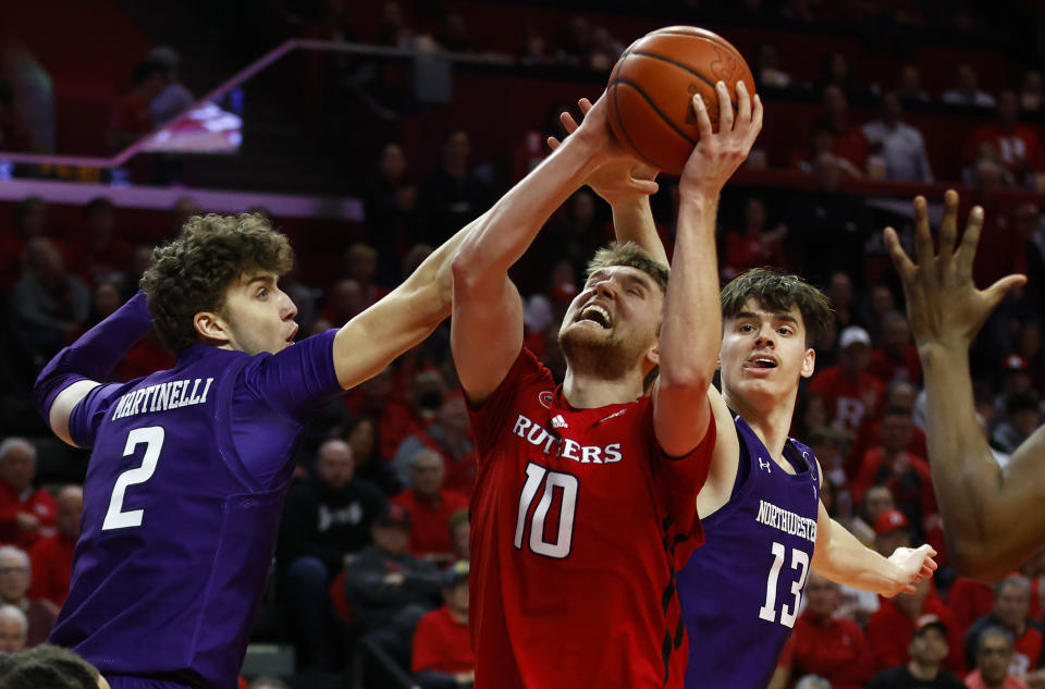 Rutgers guard Cam Spencer (10) drives to the basket against Northwestern forward Nick Martinelli (2) and guard Brooks Barnhizer (13) during the second half of an NCAA college basketball game, Sunday, March 5, 2023, in Piscataway, N.J. Northwestern won 65-53. (AP Photo/Noah K. Murray)