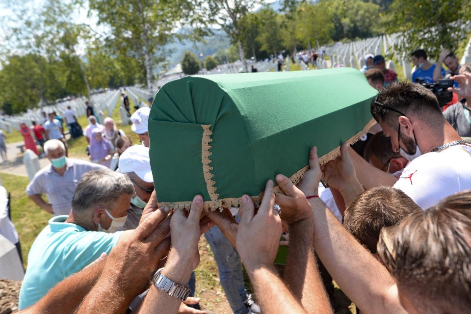 Bosnians carry the coffin of one of nine massacre victims in Potocari, near Srebrenica, Bosnia, Saturday, July 11, 2020. Mourners converged on the eastern Bosnian town of Srebrenica for the 25th anniversary of the country's worst carnage during the 1992-95 war and the only crime in Europe since World War II that has been declared a genocide. (AP Photo/Kemal Softic)