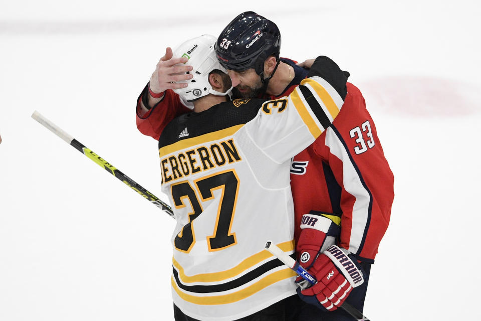 Boston Bruins center Patrice Bergeron (37) and Washington Capitals defenseman Zdeno Chara (33) hug after Game 5 of an NHL hockey Stanley Cup first-round playoff series, Sunday, May 23, 2021, in Washington. The Bruins won 3-1. (AP Photo/Nick Wass)