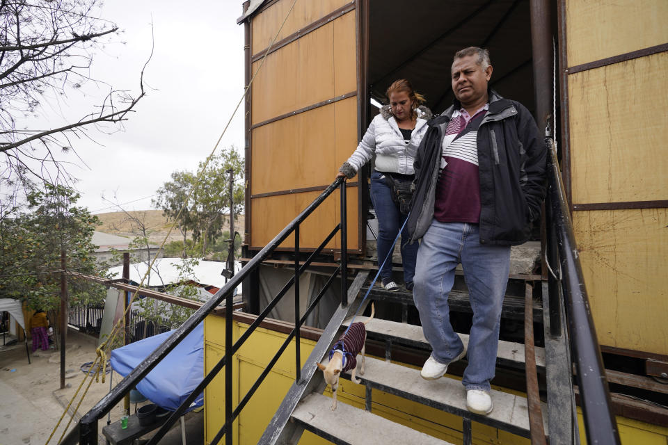 Hondurans Ana Morazan, left, and her boyfriend Fredi Juarez, walk outside of a building housing their tent a migrant shelter Friday, May 20, 2022, in the border city of Tijuana, Mexico. Back-to-back hurricanes destroyed her home in Honduras in 2020, forcing her and Juarez to join the millions of people uprooted by rising seas, drought, searing temperatures and other climate catastrophes. (AP Photo/Gregory Bull)