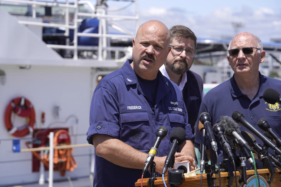 U.S. Coast Guard Capt. Jamie Frederick, left, faces reporters as Carl Hartsfield, director and senior program manager Oceanographic Systems Laboratory, center, and Paul Hankins, U.S. Navy civilian contractor, supervisor of salvage, right, look on during a news conference, Wednesday, June 21, 2023, at Coast Guard Base Boston, in Boston. The U.S. Coast Guard says sounds and banging noises have been heard from the search area for Titanic submersible. (AP Photo/Steven Senne)