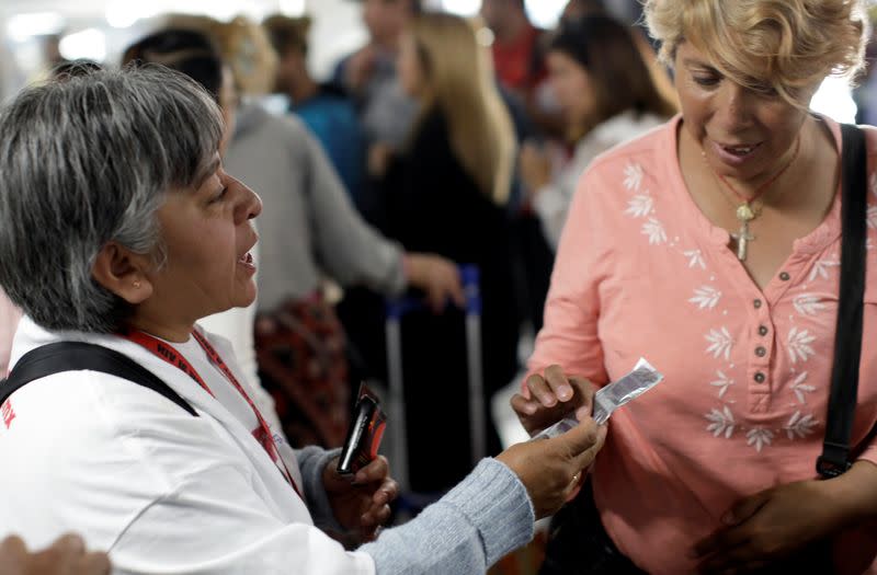 A member of an organization gives out free condoms during an event organized by AIDS Healthcare Foundation for the International Condom Day, at a metro station in Mexico City