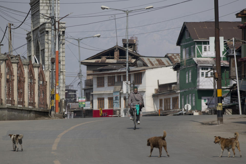 A Kashmiri cyclist rides on a deserted street during security lockdown in Srinagar, Indian controlled Kashmir, Sunday, Feb. 24, 2019. Shops and businesses have closed in Kashmir to protest a sweeping crackdown against activists seeking the end of Indian rule in the disputed region. (AP Photo/ Dar Yasin)