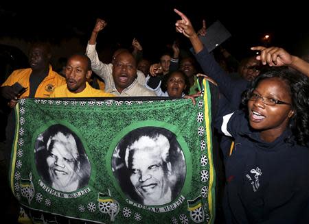 People chant slogans outside the house of former South African President Nelson Mandela after news of his death in Houghton, December 5, 2013. REUTERS/Siphiwe Sibeko