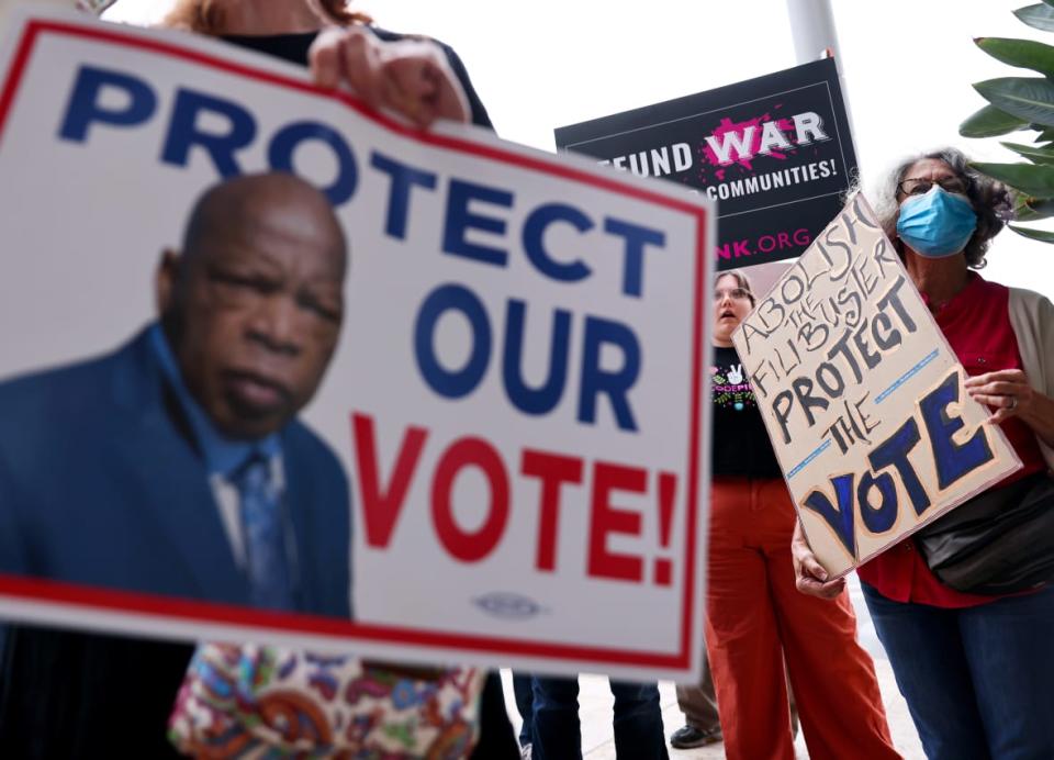 LOS ANGELES, CALIFORNIA – JULY 26: Demonstrators hold signs during a California Poor People’s Campaign protest outside the office of Sen. Dianne Feinstein (D-CA) on July 26, 2021 in Los Angeles, California. Protestors held similar demonstrations outside the offices of senators around the country calling for ending the filibuster, passage of the For the People Act, restoring the 1965 Voting Rights Act, and increasing the federal minimum wage to $15/hour. (Photo by Mario Tama/Getty Images)