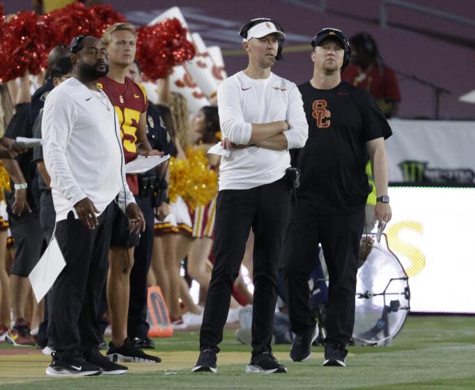 USC coach Lincoln Riley is surrounded by staff on the sideline as he watches his team beat San Jose State