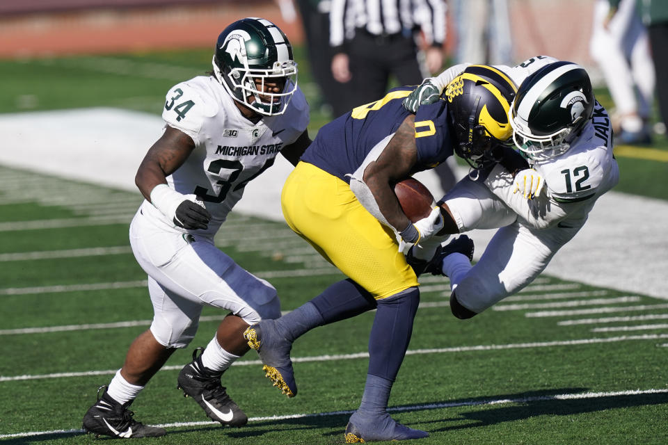 Michigan wide receiver Giles Jackson (0) is pulled out of bounds by Michigan State cornerback Chris Jackson (12) during the second half of an NCAA college football game, Saturday, Oct. 31, 2020, in Ann Arbor, Mich. (AP Photo/Carlos Osorio)