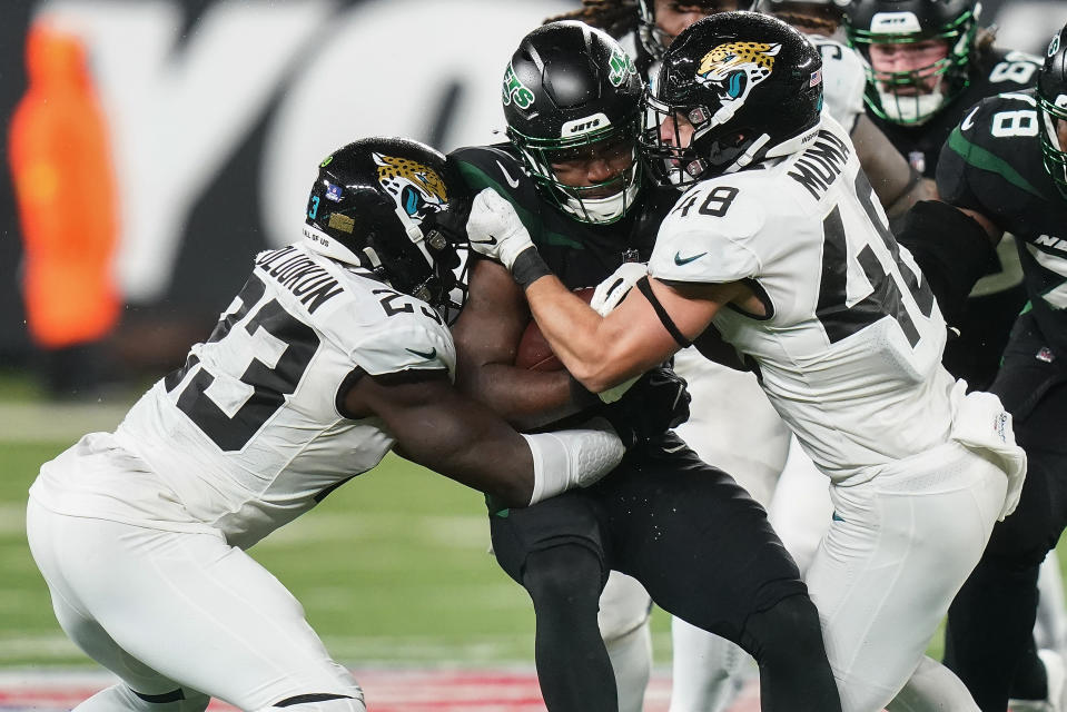 New York Jets running back Zonovan Knight (27) is tackled by Jacksonville Jaguars linebacker Foyesade Oluokun (23) and linebacker Chad Muma (48) during the third quarter of an NFL football game, Thursday, Dec. 22, 2022, in East Rutherford, N.J. (AP Photo/Frank Franklin II)