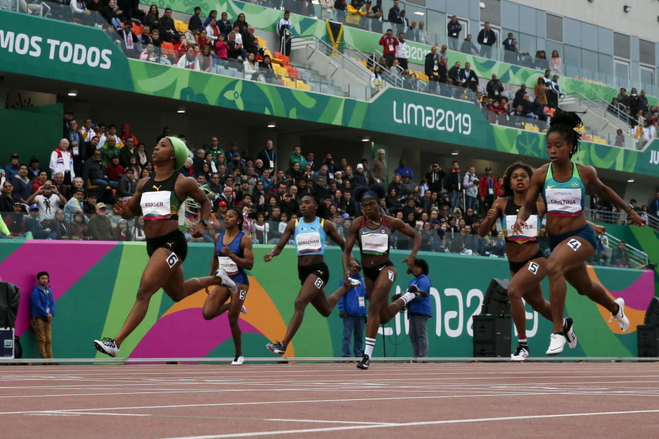 Shelly-Ann Fraser-Pryce of Jamaica, left, wins the gold medal and sets a new Pan American record in the women's 200m final during the athletics at the Pan American Games in Lima, Peru, Friday, Aug. 9, 2019. (AP Photo/Moises Castillo)