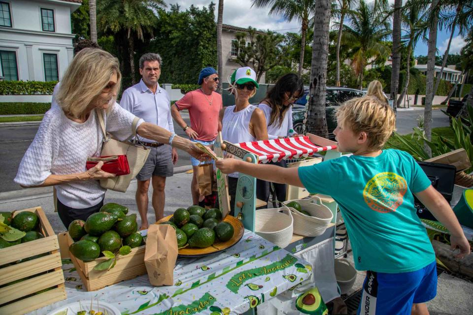 Consuelo Hutton, left, purchases avocados from Asher Leidy, 9.