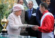 <p>The Queen presenting a jockey with an award at the 2017 races.</p>