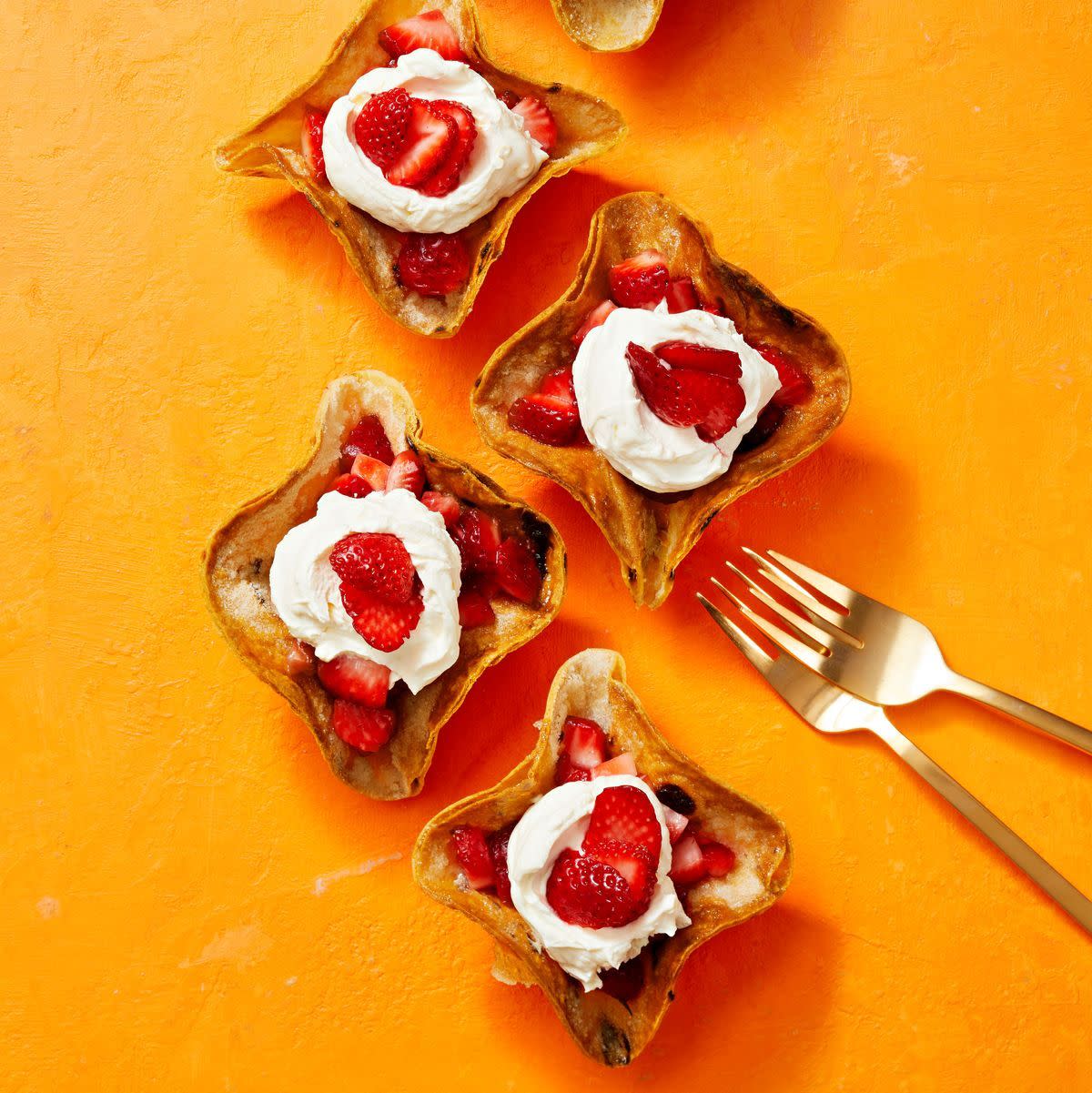 crispy tortilla bowls with strawberries and cream on an orange background