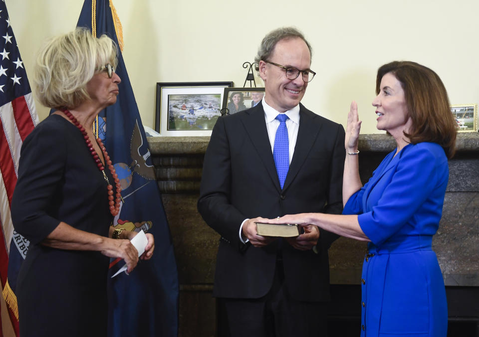 New York Chief Judge Janet DiFiore, left, swears in Kathy Hochul, right, as the first woman to be New York's governor while her husband Bill Hochul holds a bible during a swearing-in ceremony in the Red Room at the state Capitol, early Tuesday, Aug. 24, 2021, in Albany, N.Y. (AP Photo/Hans Pennink, Pool)