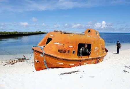 FILE PHOTO: A Filipino soldier looks out from a boat in Philippine occupied Thitu island in disputed South China Sea, April 21, 2017. REUTERS/Erik De Castro