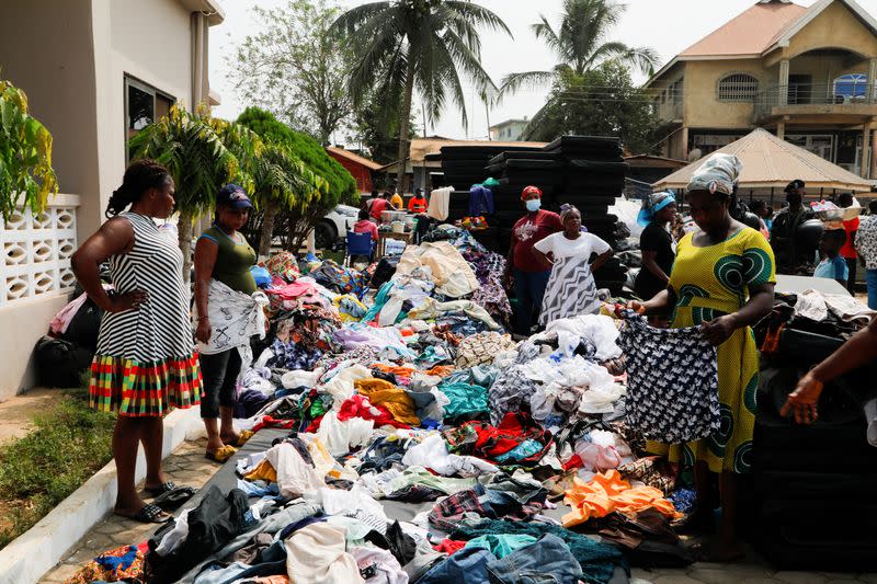 People sort used clothes donated to members of the Apiate community whose homes were destroyed when a vehicle carrying mining explosives detonated along a road, in Bogoso
