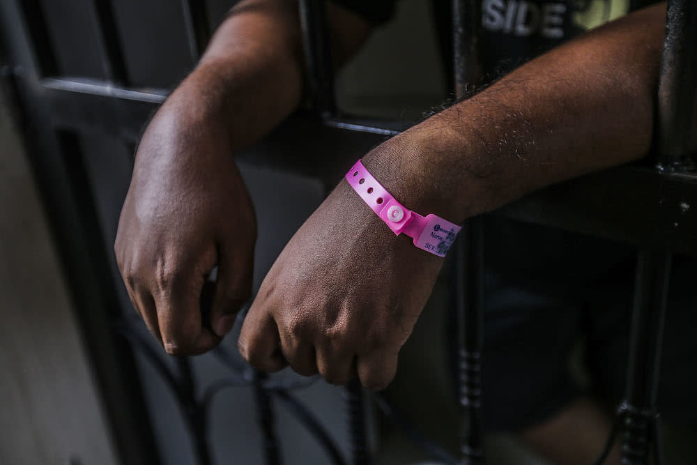 A man is seen standing at his house gate after being ordered to undergo home quarantine in Kuala Lumpur October 4, 2020. — Picture by Hari Anggara.