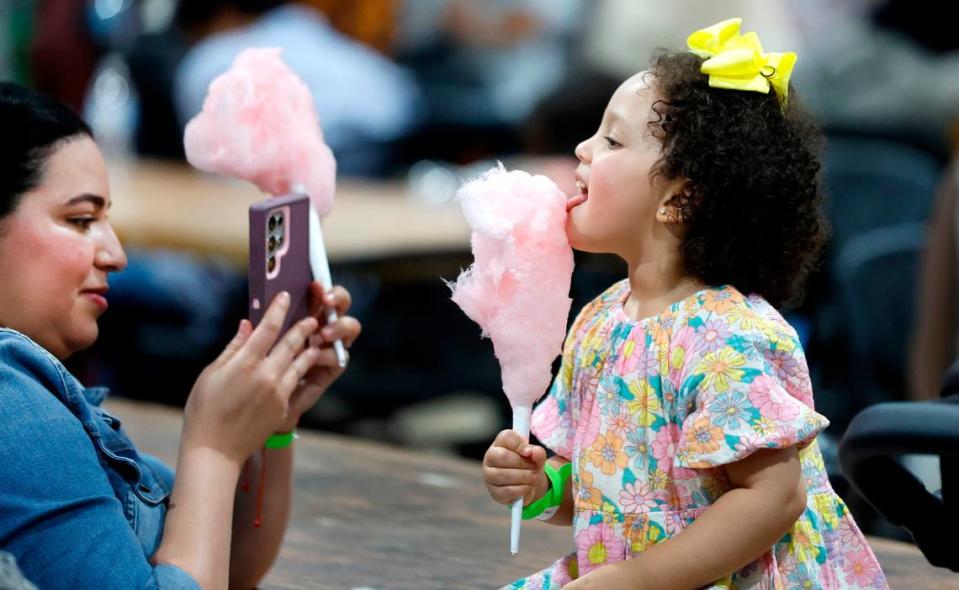 Sanaa Achik takes a photo of her daughter Jana Bendhiba, 2, as she enjoys cotton candy during the Eid Festival at the Jim Graham Building in Raleigh, N.C. Saturday, June 22, 2024. Eleven Triangle mosques and Islamic organizations joined forces to hold what was billed as North Carolina’s largest Eid festival.