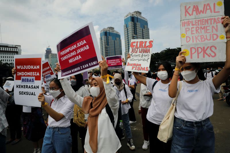 FILE PHOTO: Activists carrying placards take part in a rally to support women's rights calling for gender equality and to protest against gender discrimination, during the International Women's Day outside the National Monument (Monas) complex in Jakarta