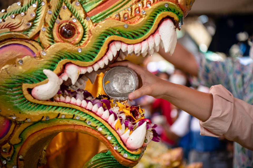 SAMUT PRAKAN, THAILAND - 2021/04/14: A person pouring water into a Serpent statue during the Songkran celebration also known as the Thai New Year, at Bang Phli Yai Temple. (Photo by Amphol Thongmueangluang/SOPA Images/LightRocket via Getty Images)