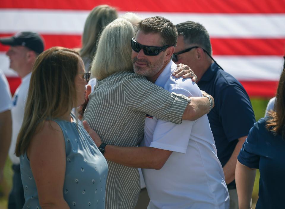 Air Force veteran Francis "Frankie" Reilly shares a hug from Kristine Cohn, of Ibis Charities, while talking with Port St. Lucie Mayor Shannon Martin (left)  during groundbreaking for a mortgage-free home for Frankie and his family on Monday, May 22, 2023, in Port St. Lucie. PulteGroup will build a 4-bedroom/3-bath home on an estate lot in Heron Preserve as part of PulteGroup's Built to Honor program, in partnership with Homes for Heroes, building mortgage-free homes for veterans.