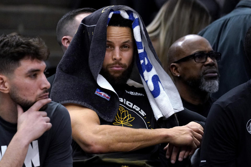 Golden State Warriors guard Stephen Curry, center, sits on the bench during the second half of an NBA basketball game against the Chicago Bulls in Chicago, Sunday, Jan. 15, 2023. (AP Photo/Nam Y. Huh)