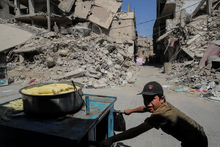 A child pushes a cart selling cooked sweetcorn in Douma, outside Damascus, Syria, September 17, 2018. The town of Douma in eastern Ghouta was retaken by the government from rebels in April after heavy fighting and intense army bombardment and air strikes. REUTERS/Marko Djurica/Files