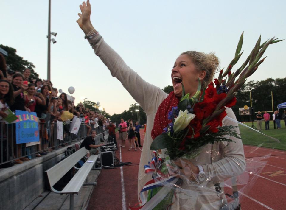 Elizabeth Beisel, winner of two Olympic medals for swimming in the 2012 London Olympics, returned home to Rhode Island today and was greeted by hundreds of fans who gathered at North Kingston High School to welcome her back and show their appreciation. Elizabeth Beisel waves to fans after her arrival at the North Kingstown HS football field. [The Providence Journal/Bob Breidenbach]