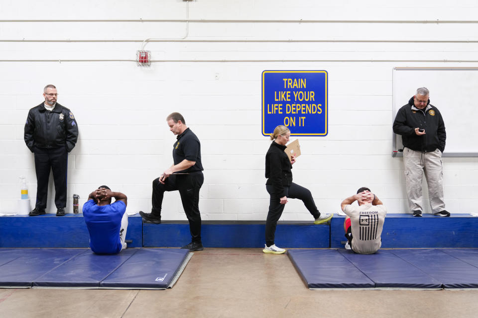 Philadelphia Police Academy staff count sit ups during applicants' physical fitness entry exam in Philadelphia, Saturday, Feb. 24, 2024. The city has moved to lower requirements for the entry physical exam at its police academy as part of a broader effort nationally to reevaluate policies that keep law enforcement applicants out of the job pool amid a hiring crisis. (AP Photo/Matt Rourke)
