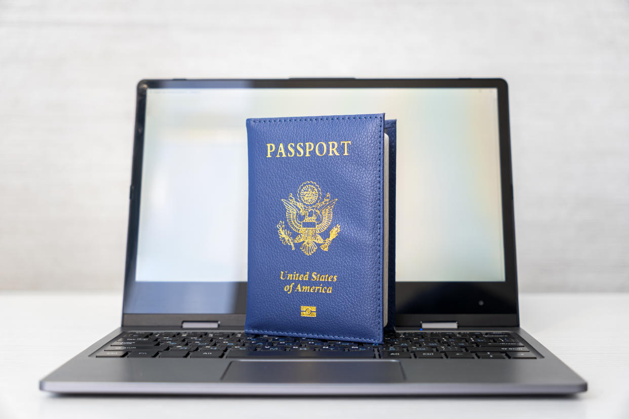 A U.S. passport propped up on a laptop keyboard.