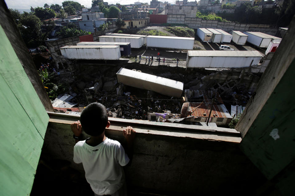 Child looks at the site where a landslide took place