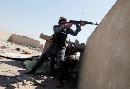 An Iraqi federal policeman fires his rifle at Islamic State fighters' positions at Bab al Jadid district in the old city of Mosul, Iraq, March 26, 2017. REUTERS/Youssef Boudlal