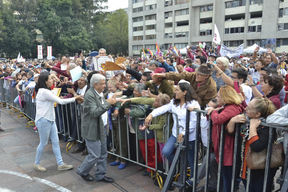 Mexico's President-elect Andres Manuel Lopez Obrador greets people gathered at a rally commemorating the 50th anniversary of a bloody reprisal against students, at the Tlatelolco Plaza in Mexico City, Saturday, Sept. 29, 2018. Lopez Obrador vowed Saturday to never use military force against civilians. Troops fired on a peaceful demonstration at the plaza on Oct. 2, 1968, killing as many as 300 people at a time when leftist student movements were taking root throughout Latin America. (AP Photo/Christian Palma)