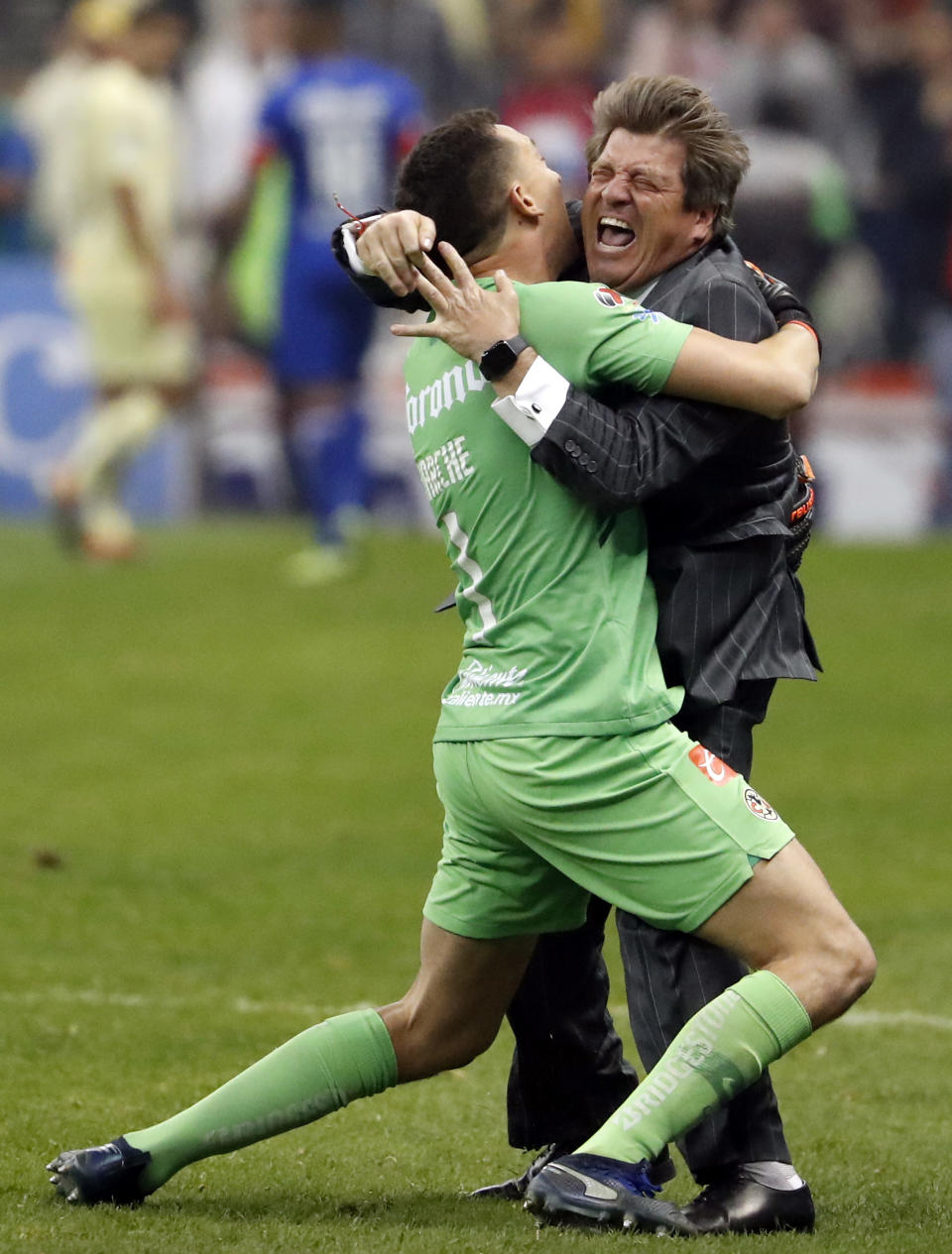 America coach Miguel Herrera and goalkeeper Agustin Marchesin embrace after defeating Cruz Azul in the final Mexico soccer league championship match at Azteca stadium in Mexico City, on Sunday, Dec. 16, 2018. America defeated Cruz Azul 2-0 on Sunday to become the champion of the Mexican Apertura tournament, which earned them their 13th league title, becoming the most successful team in the country. (AP Photo/Eduardo Verdugo)