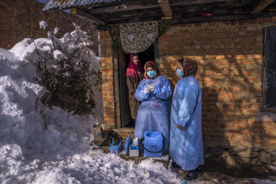 Fozia, a healthcare worker, prepares the Covishield vaccine for COVID-19 before administering to an elderly woman during a COVID-19 vaccination drive in Budgam, southwest of Srinagar, Indian controlled Kashmir, Jan. 11, 2022. (AP Photo/Dar Yasin)