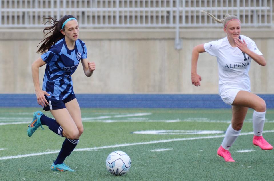 Petoskey's Kate Farley pushes the ball down the field in the first half against Alpena with a Wildcat defender giving chase.