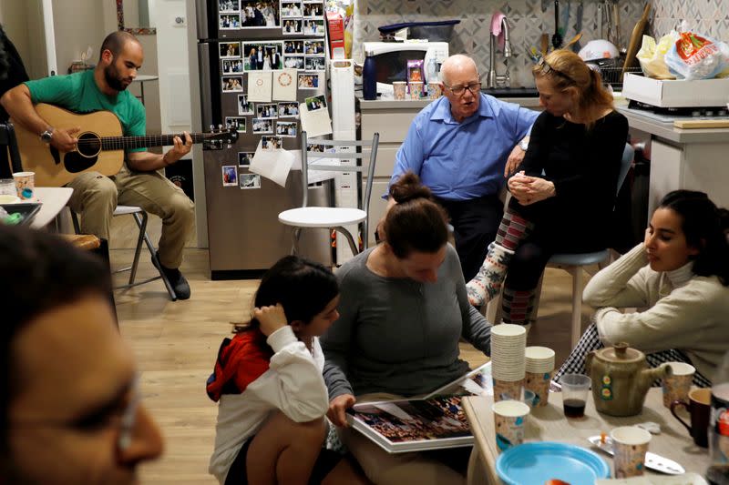 Members of the Avivi family gather together after lighting a hanukkiyah, a candlestick with nine branches that is lit to mark Hanukkah, the 8-day Jewish Festival of Lights, in Tel Aviv, Israel