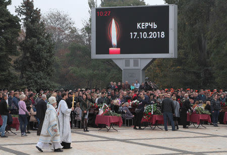 People attend a memorial ceremony before the funeral of victims of an attack on a local college in the city of Kerch, Crimea October 19, 2018. The inscription on the screen reads "Kerch. 17.10.2018". REUTERS/Pavel Rebrov