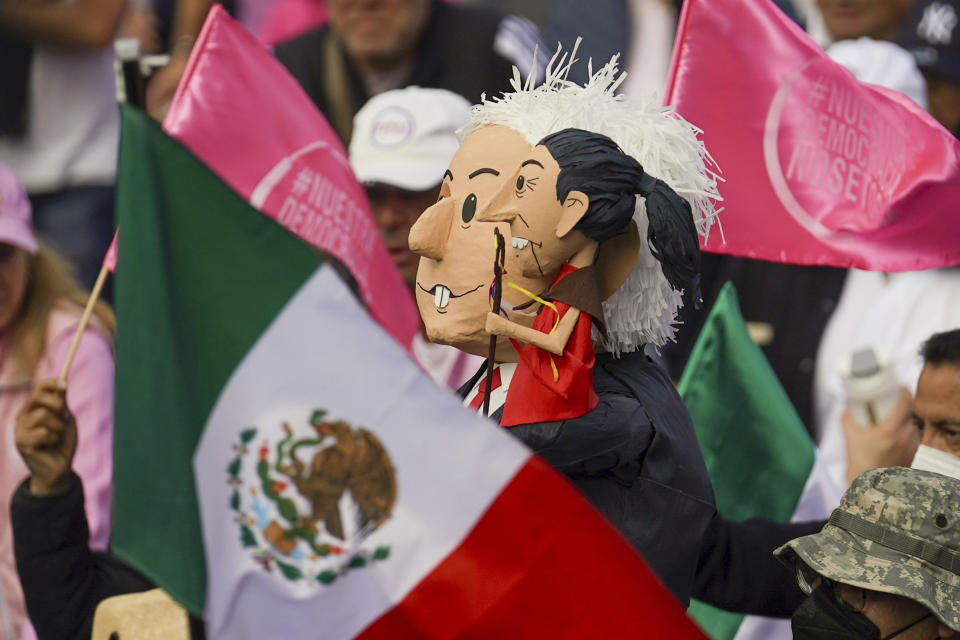 Manifestantes portan muñecos con la imagen del presidente de México, Andrés Manuel López Obrador, y de la candidata presidencial, Claudia Sheinbaum, durante una marcha convocada por organizaciones ciudadanas para exigir que se respete a la autoridad electoral en las próximas elecciones generales, el domingo 18 de febrero de 2024, en la Ciudad de México. (AP Foto/Marco Ugarte)