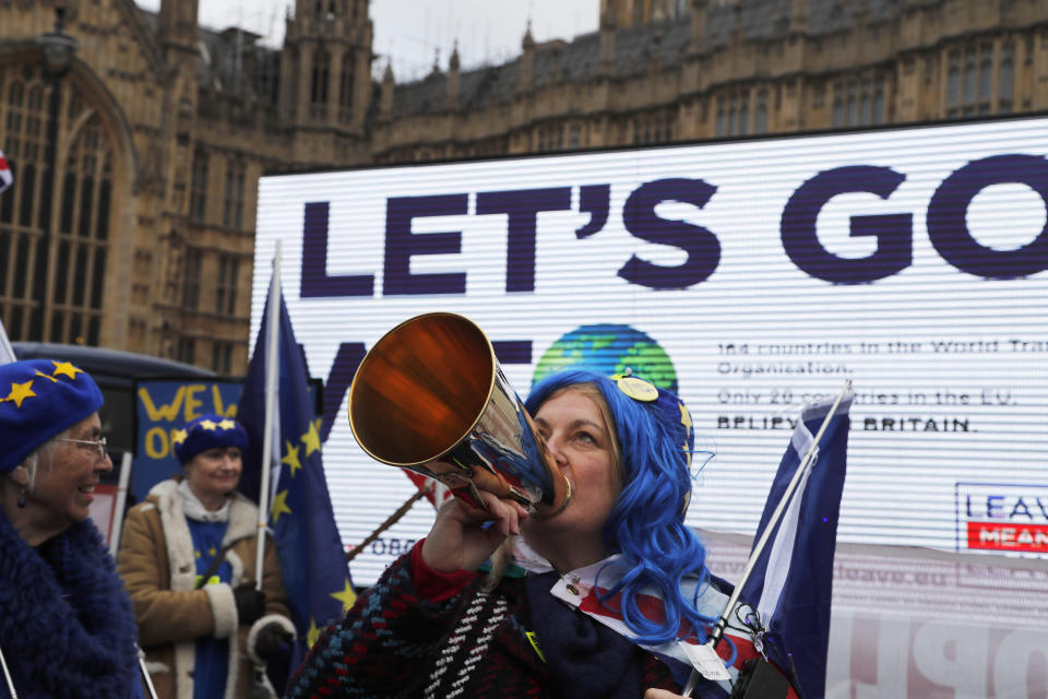 A Pro-European demonstrator protests in front of a Leaver campaign board opposite the Houses of Parliament in London, Tuesday, Jan. 15, 2019. Britain's Prime Minister Theresa May is struggling to win support for her Brexit deal in Parliament. Lawmakers are due to vote on the agreement Tuesday, and all signs suggest they will reject it, adding uncertainty to Brexit less than three months before Britain is due to leave the EU on March 29. (AP Photo/Frank Augstein)