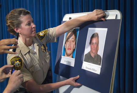 Metro Police Officer Laura Meltzer posts photos of the two shooting suspects Jerad and Amanda Miller during a news conference at Metro Police headquarters in Las Vegas June 9, 2014. REUTERS/Las Vegas Sun/Steve Marcus
