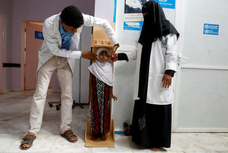 Nurses measure the height of Afaf Hussein, 10, who is malnourished, at a clinic in Aslam, in the northwestern province of Hajjah, Yemen, February 17, 2019. Afaf, who now weighs around 11 kg and is described by her doctor as "skin and bones", has been left acutely malnourished by a limited diet during her growing years and suffering from hepatitis, likely caused by infected water. She left school two years ago because she got too weak. REUTERS/Khaled Abdullah