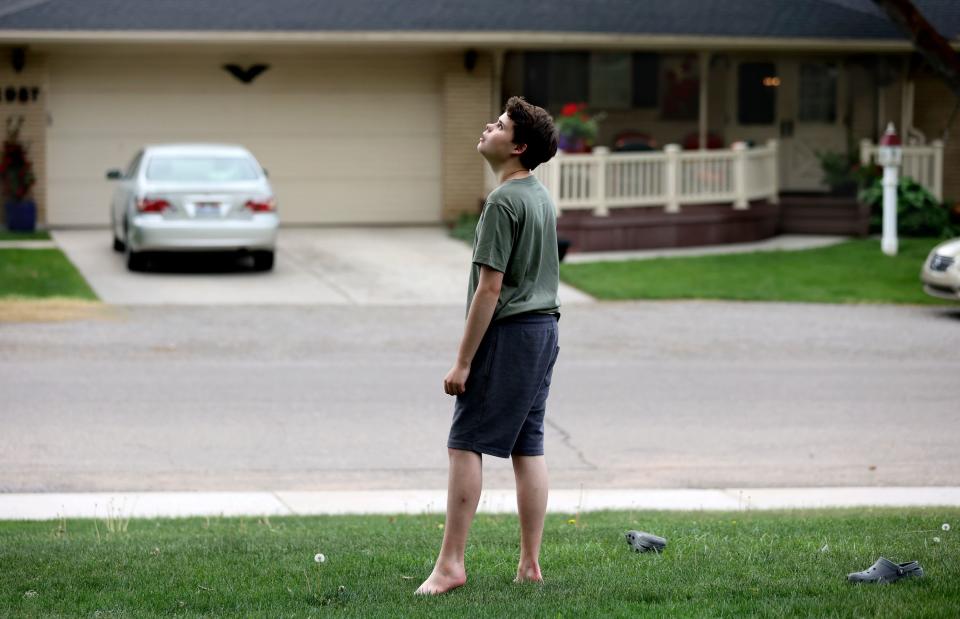 Connor Campbell, 16, walks barefoot and looks up at the sky in his neighborhood in Provo on Sunday, May 28, 2023. Connor is autistic, nonverbal and has epilepsy. He lives at the Utah State Developmental Center in American Fork but comes home on Sundays. | Kristin Murphy, Deseret News