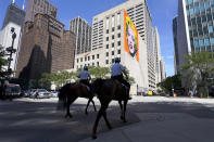 CORRECTS YEAR TO 2020 NOT 2019 Chicago mounted police officers patrol Chicago's Magnificent Mile with an Andy Warhol mural of Marilyn Monroe in the background, on Tuesday, Aug. 11, 2020. (AP Photo/Charles Rex Arbogast)