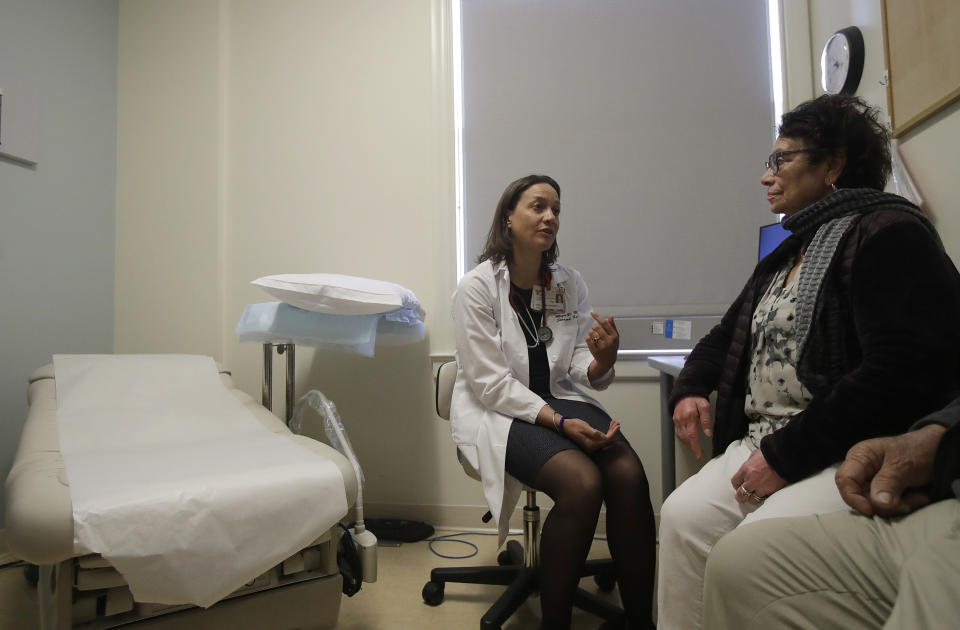 In this April 9, 2019 photo, Dr. Megan Mahoney, left, talks with patient Consuelo Castaneda at the Stanford Family Medicine office in Stanford, Calif. Health care experts say the changing, fragmented nature of care is precisely why people still need someone who looks out for their overall health, which is the traditional role of primary care physicians like family doctors and pediatricians. (AP Photo/Jeff Chiu)